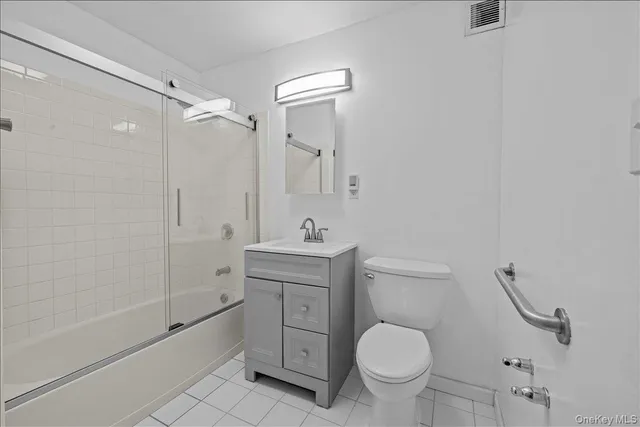 a bathroom with a granite countertop toilet a sink and a mirror