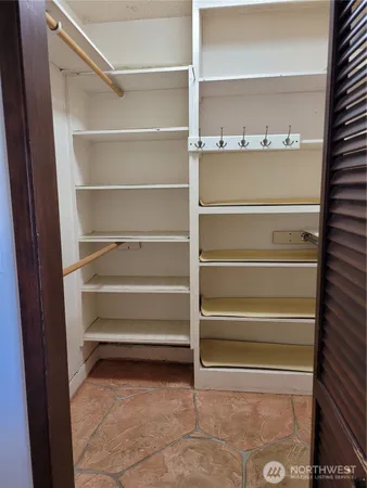 a view of walk in closet with empty racks