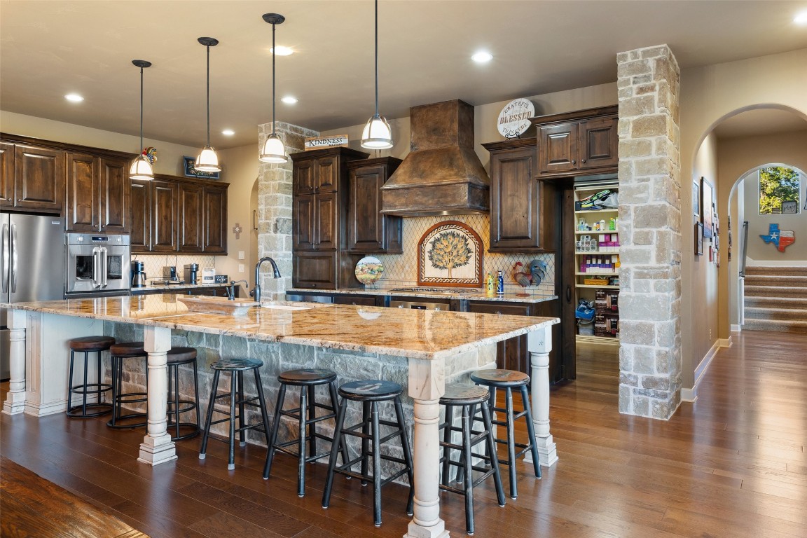 1039 Bluewater Place Spring Branch, TX 78070 - Photo 13 of 40 a kitchen with stainless steel appliances granite countertop a stove a refrigerator and kitchen island with wooden floor