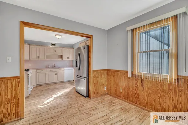 a view of a kitchen with a sink and dishwasher with wooden floor