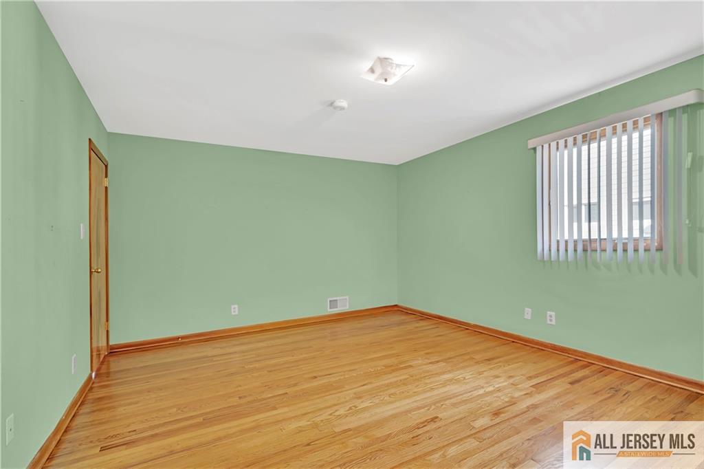 306 Austin Avenue Old Bridge, NJ 08857 - Photo 23 of 39 an empty room with wooden floor and windows