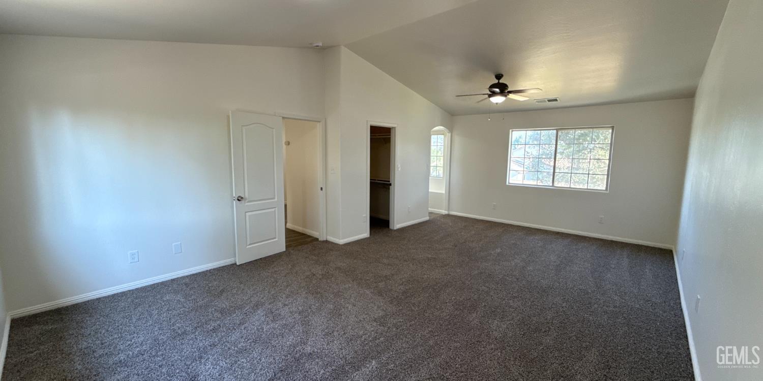 Undisclosed Address Bakersfield, CA 93312 - Photo 12 of 20 an empty room with windows and chandelier fan