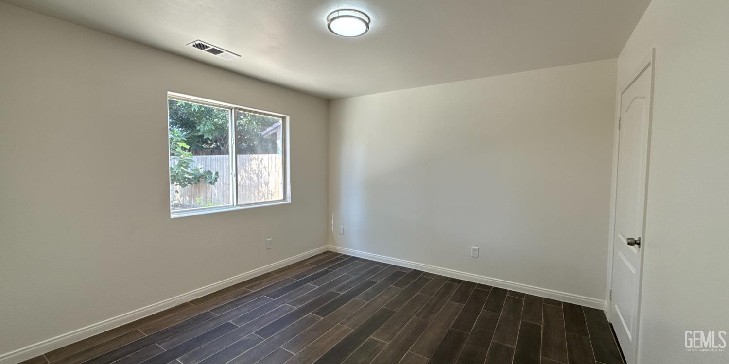 Undisclosed Address Bakersfield, CA 93312 - Photo 8 of 20 an empty room with wooden floor and windows