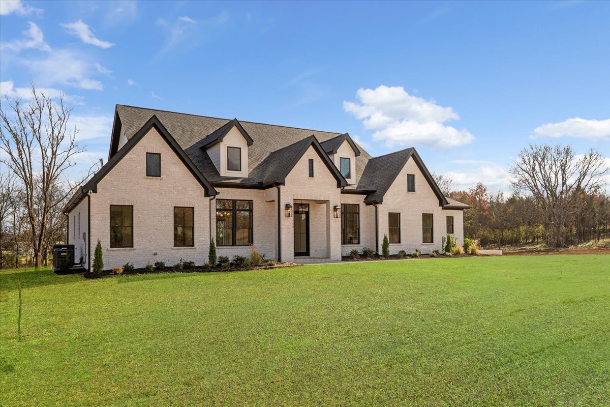 2412 Joe Brown Road Spring Hill, TN 37174 - Photo 41 of 86 a front view of a house with a garden and trees
