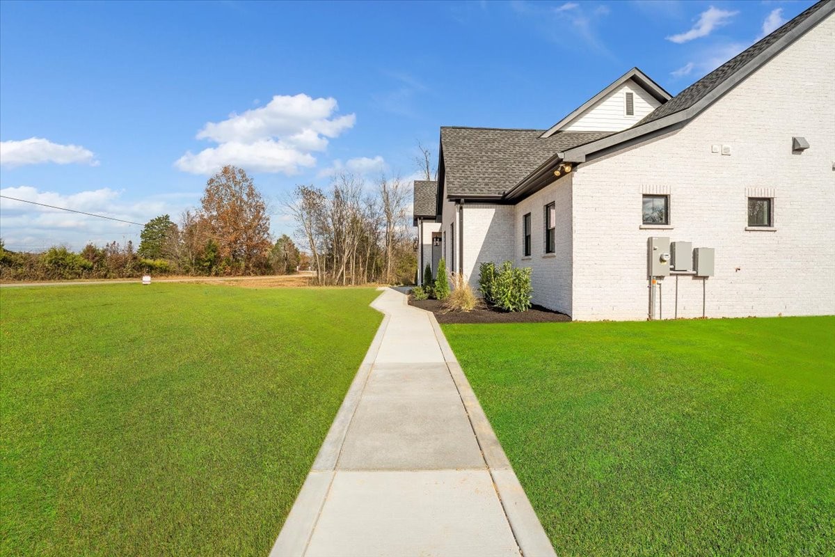 2412 Joe Brown Road Spring Hill, TN 37174 - Photo 50 of 86 a view of a white house next to a yard with big trees