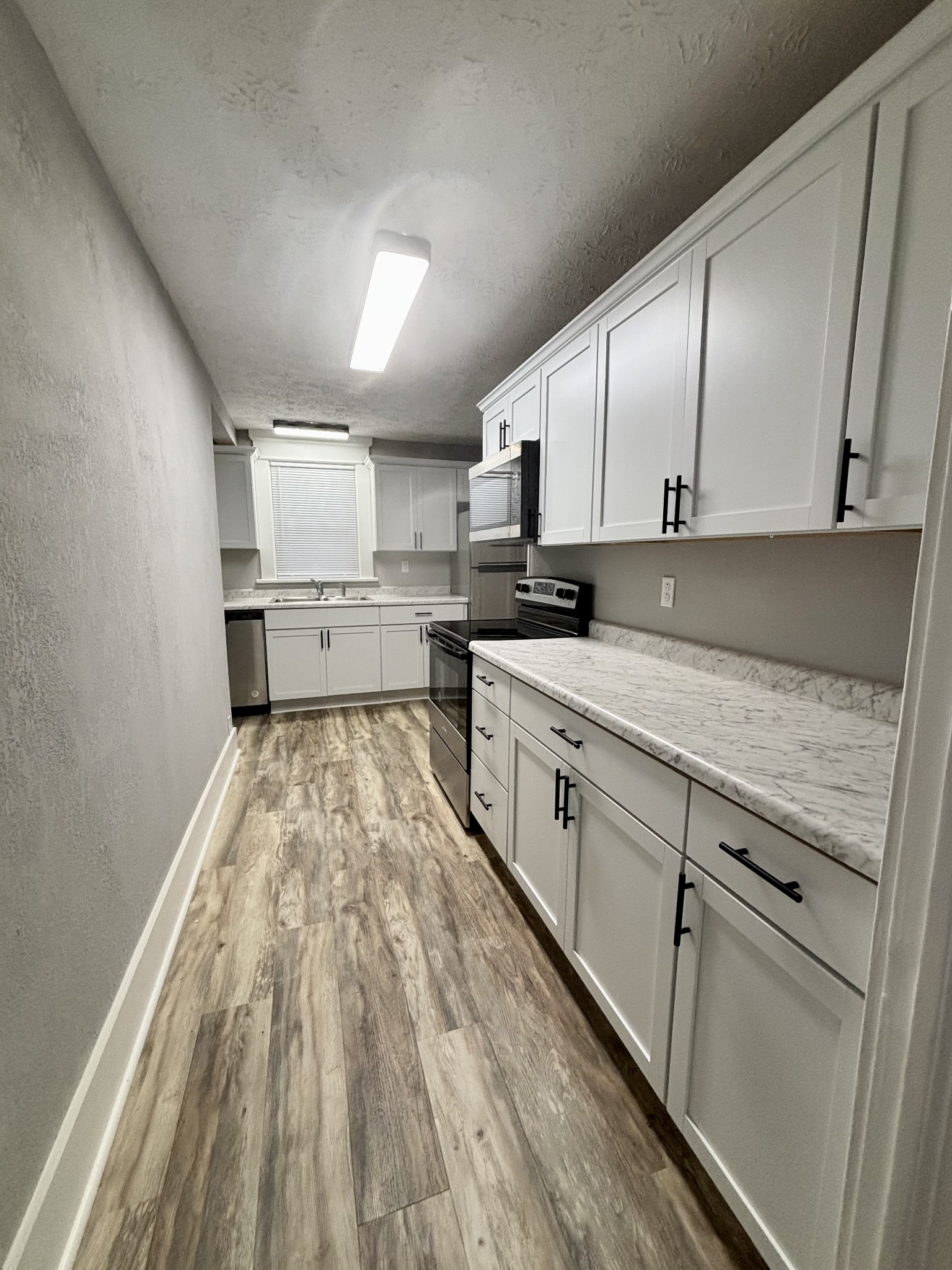 40 Line Street Cadiz, KY 42211 - Photo 13 of 53 a kitchen with kitchen island granite countertop wooden cabinets and white appliances