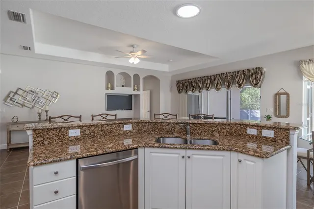 a kitchen with granite countertop a sink and cabinets