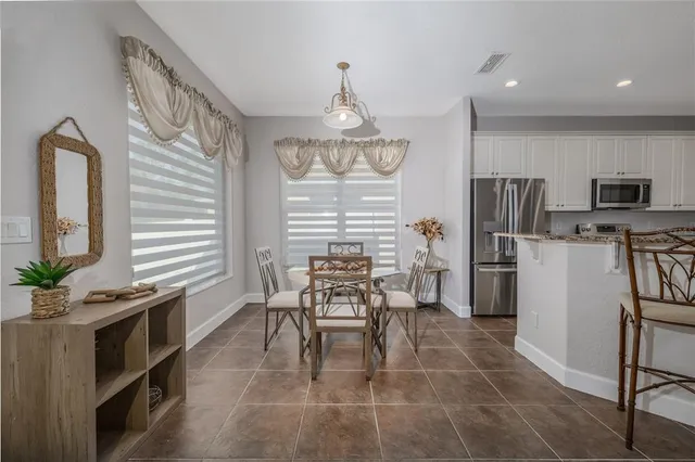 a dining room filled chandelier and kitchen view