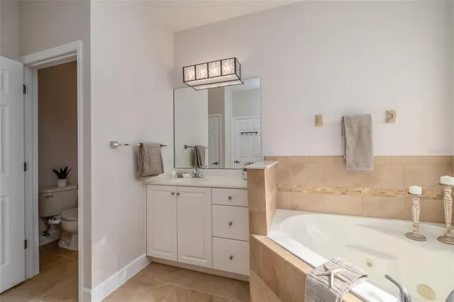 a spacious bathroom with a bathtub sink and mirror