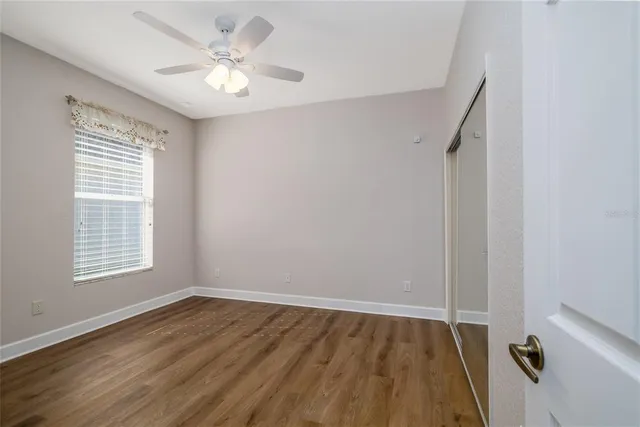 an empty room with a window and a ceiling fan
