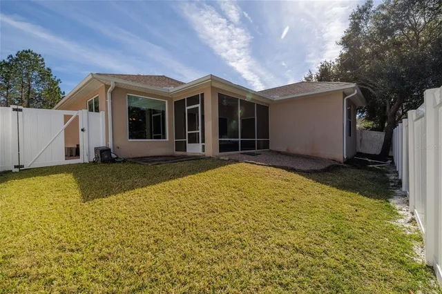 a view of yellow house with swimming pool in front of it
