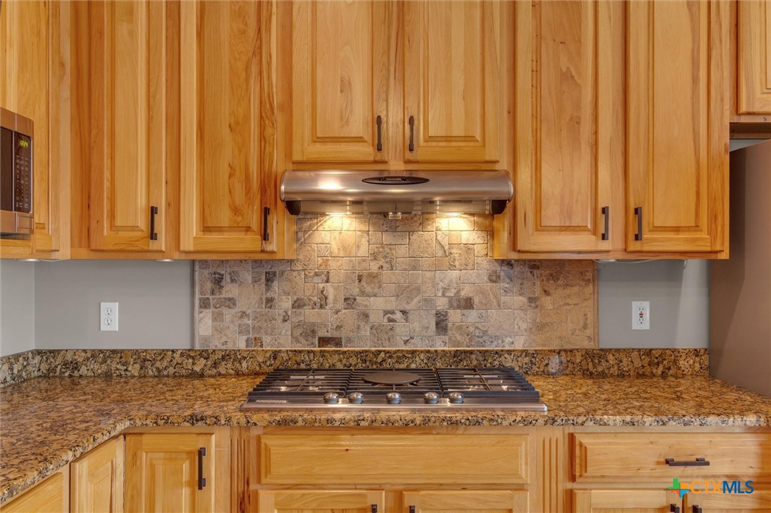 2235 Summit Ridge San Marcos, TX 78666 - Photo 14 of 38 a kitchen with granite countertop cabinets and a stove top oven