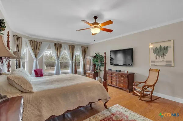 a bedroom with a bed a window and a flat screen television