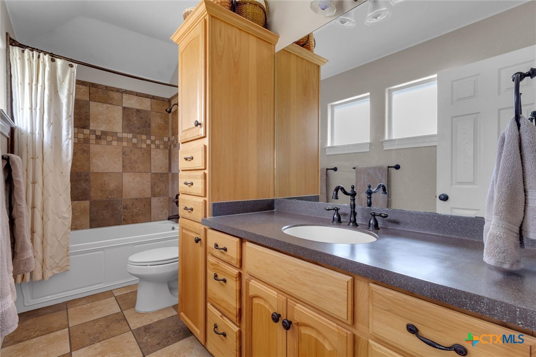 2235 Summit Ridge San Marcos, TX 78666 - Photo 28 of 38 a bathroom with a granite countertop sink toilet and shower