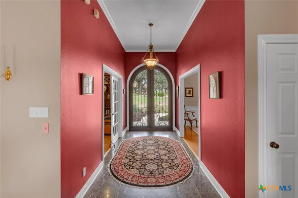 a dining room with wooden floor a chandelier a wooden table and chairs