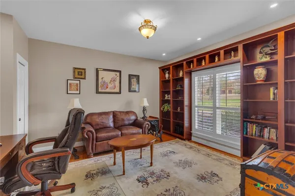a dining room with furniture a chandelier and wooden floor