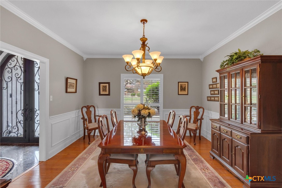 2235 Summit Ridge San Marcos, TX 78666 - Photo 7 of 38 a dining room with wooden floor a chandelier a wooden table and chairs