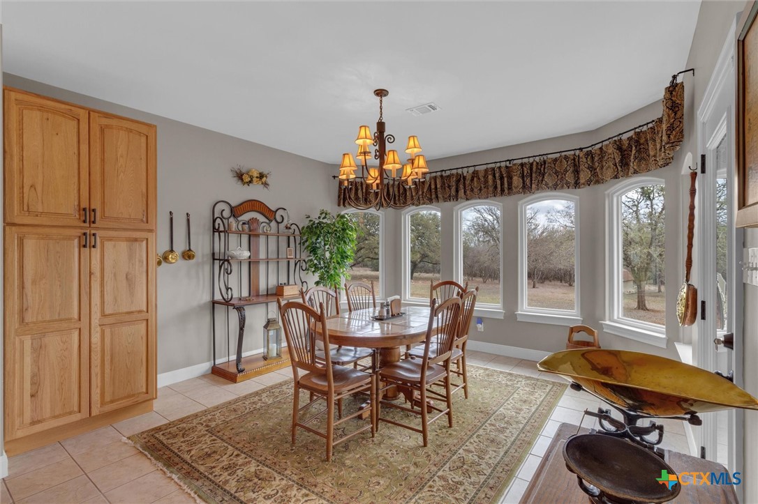 2235 Summit Ridge San Marcos, TX 78666 - Photo 8 of 38 a dining room with furniture a chandelier and wooden floor
