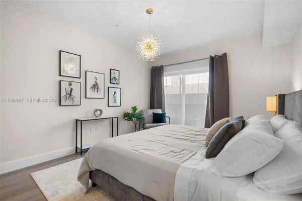 a bedroom with a bed lamps and a large mirror on the dresser