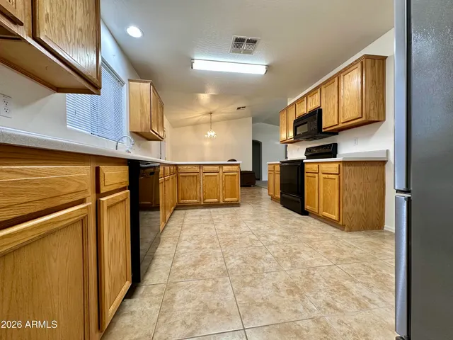 a kitchen with stainless steel appliances granite countertop a refrigerator a stove and a sink with granite countertops