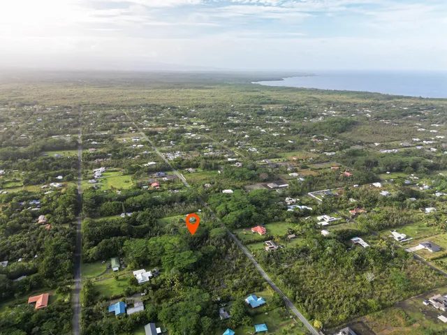 an aerial view of house with yard and mountain view in back