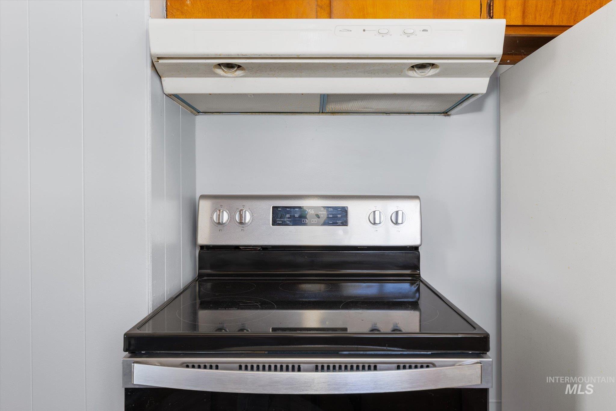 918 West 3rd Street Weiser, ID 83672 - Photo 15 of 36 Stainless steel electric range with a black ceramic cooktop, complemented by a white overhead range hood