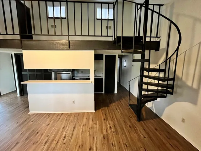a view of a living room with wooden floor and staircase