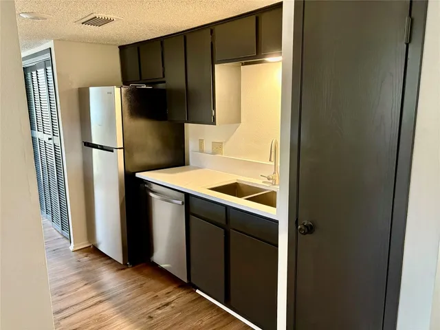 a kitchen with metallic refrigerator and a refrigerator