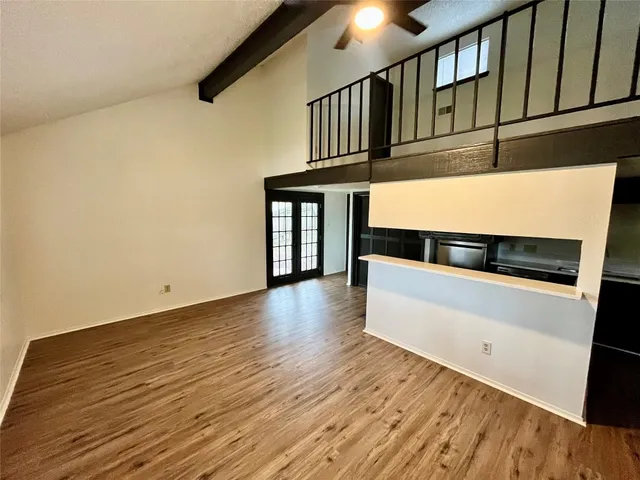 a view of an empty room with wooden floor