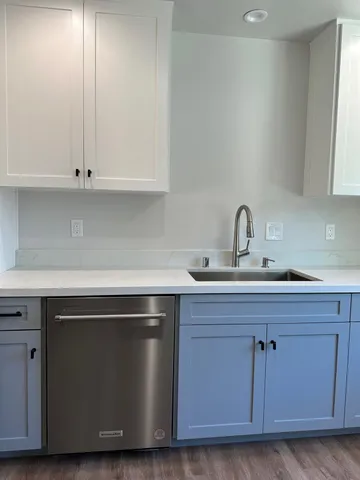 a bathroom with a granite countertop shower sink vanity and toilet