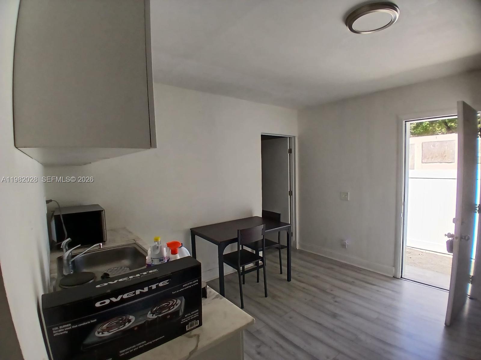1053 Northeast 149th Street Miami, FL 33161 - Photo 13 of 13 a view of a workspace with furniture and wooden floor