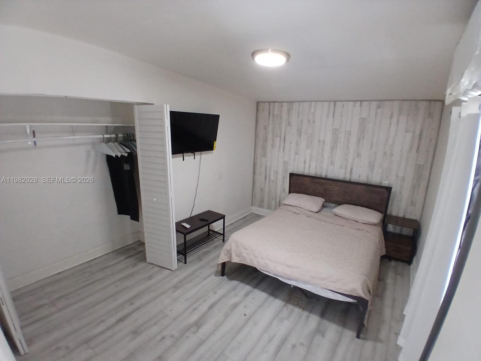 1053 Northeast 149th Street Miami, FL 33161 - Photo 7 of 13 a bedroom with a bed and a walk in closet