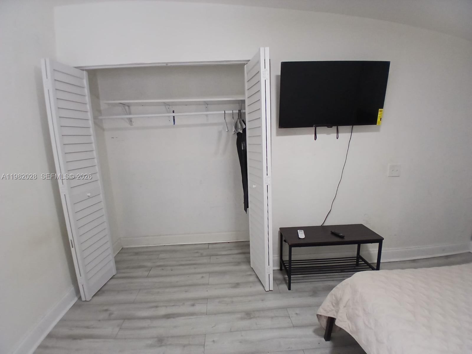 1053 Northeast 149th Street Miami, FL 33161 - Photo 8 of 13 a bedroom with a bed and a flat screen tv