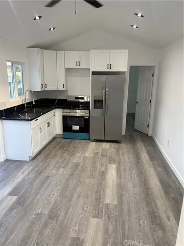 a kitchen with granite countertop a refrigerator and a sink