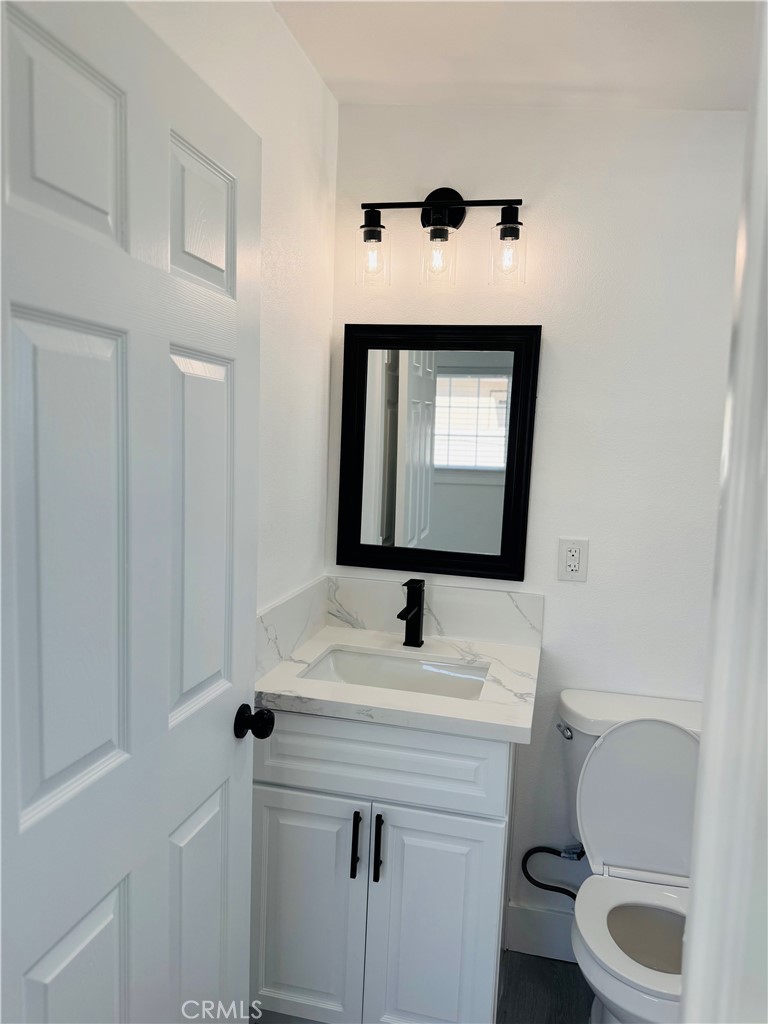 9314 Martha Way Riverside, CA 92503 - Photo 16 of 25 a bathroom with a toilet sink and mirror