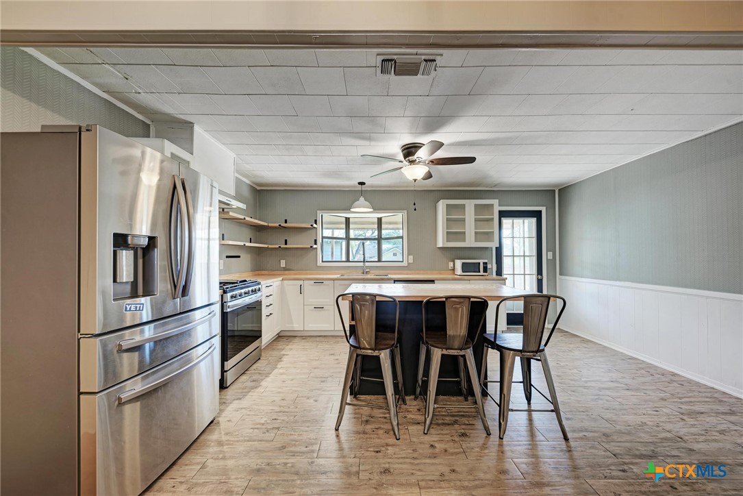 501 North Ridge Street Lampasas, TX 76550 - Photo 20 of 46 a kitchen with stainless steel appliances granite countertop a dining table chairs and chandelier