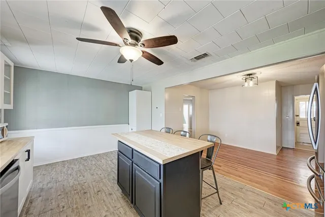 a room with a chandelier and wooden floor