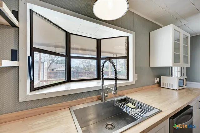 a kitchen with a stove a sink and a window