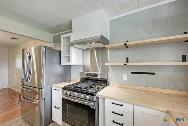 a kitchen with stainless steel appliances a stove and a refrigerator