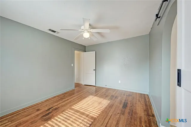 a view of a room with wooden floor and ceiling fan