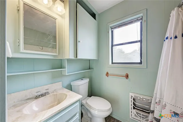 a white toilet sitting next to a bathroom sink
