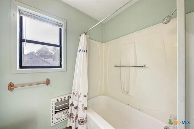 a bath tub sitting next to a white shower curtain