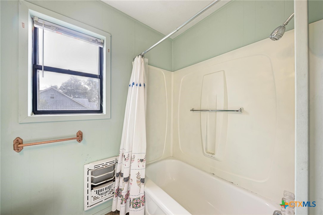 501 North Ridge Street Lampasas, TX 76550 - Photo 34 of 46 a bath tub sitting next to a white shower curtain