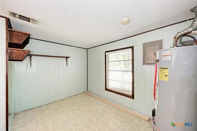 a view of empty room with windows and refrigerator