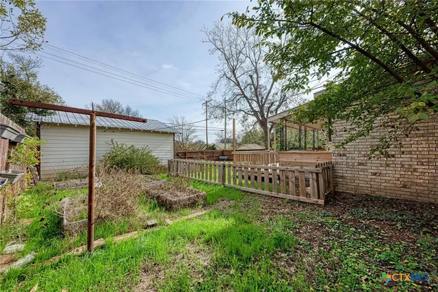 a view of a garden with wooden fence