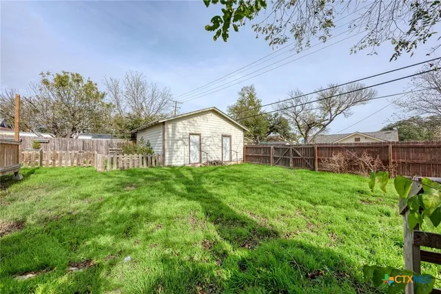 a view of a house with backyard and a garden