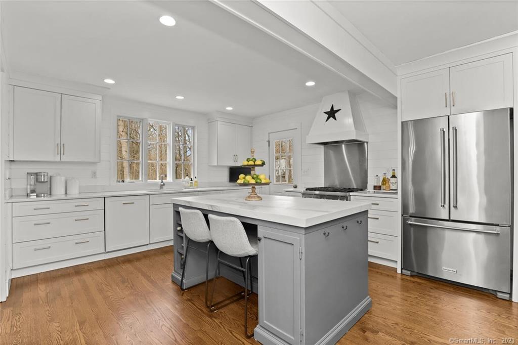 183 Frogtown Road New Canaan, CT 06840 - Photo 10 of 37 a kitchen with stainless steel appliances granite countertop a refrigerator a sink dishwasher a stove and white cabinets with wooden floor