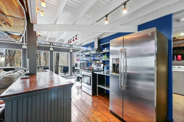 a kitchen with stainless steel appliances granite countertop a refrigerator a sink and a stove