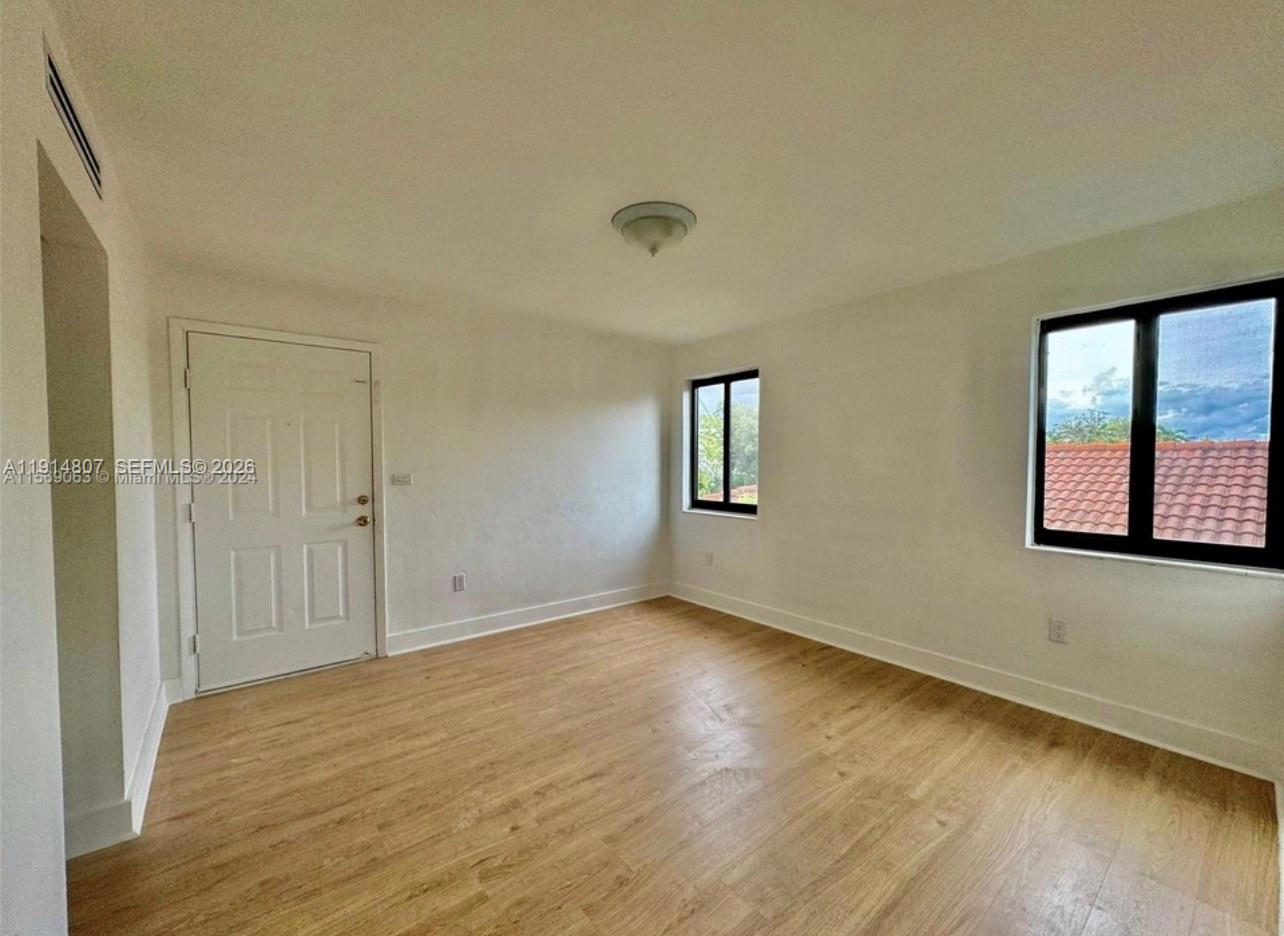 3520 Southwest 25th Street, Unit 3520 Miami, FL 33133 - Photo 7 of 18 a view of an empty room with wooden floor and a window