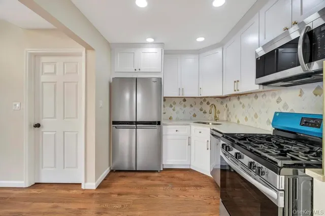 a kitchen with white cabinets and white appliances